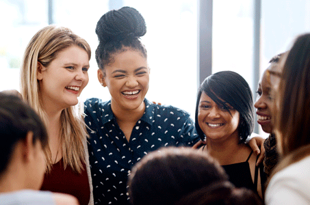 A group of young people are gathered together smiling.