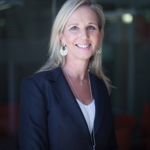 Photograph of Jane Burns smiling wearing a dark blue suit jacket and white shirt